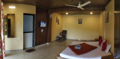 sala de estar con cama y ventilador de techo en Bluebell Residency, en Mahabaleshwar