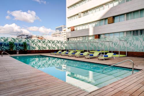 een zwembad met ligstoelen naast een gebouw bij VIP Grand Lisboa Hotel & Spa in Lissabon