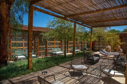 una pareja sentada en un patio bajo una pérgola en Terrantai Lodge, en San Pedro de Atacama