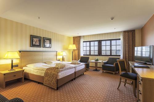 a hotel room with a bed and a desk at Maritim Hotel Dresden in Dresden