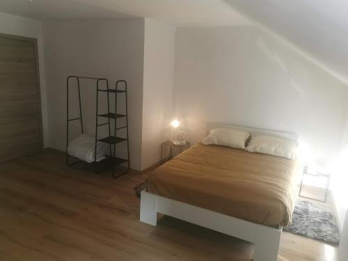 - une chambre avec un grand lit et une chaise dans l'établissement Le caillou Blanc, à Charleroi