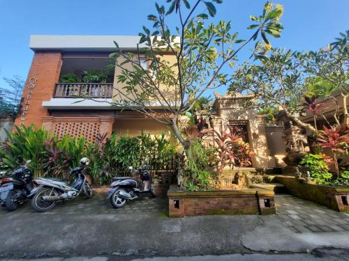 dos motocicletas estacionadas frente a una casa en Sahadewa House, en Ubud