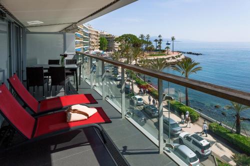 een rode stoel op een balkon met uitzicht op de oceaan bij Royal Antibes - Luxury Hotel, Résidence, Beach & Spa in Antibes