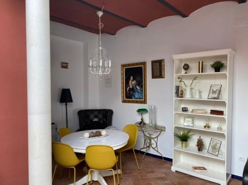 uma sala de jantar com uma mesa branca e cadeiras amarelas em Casa Boutique Eros em Carmona