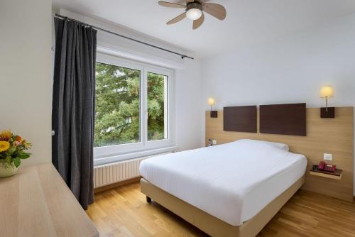 a bedroom with a white bed and a window at Bon Port in Montreux