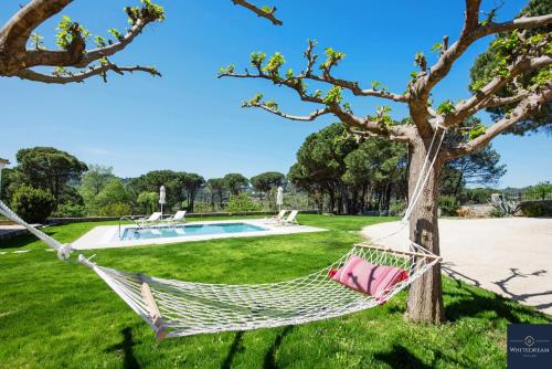 a hammock hanging from a tree next to a pool at Villa Pine Forest in Corfu Town