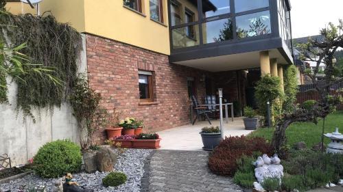 ein Backsteinhaus mit einem Balkon und einer Terrasse in der Unterkunft Ferienwohnung Le in Adenau