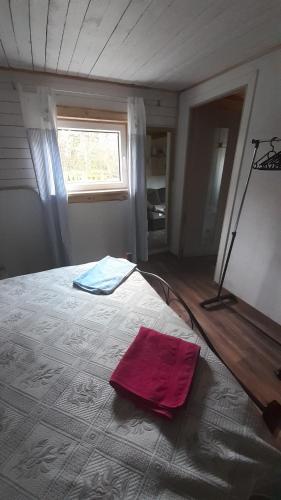 een slaapkamer met een bed met een rode handdoek erop bij Kapteni suvekodu in Laulasmaa