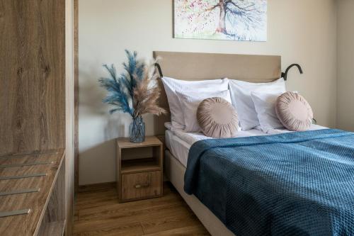 een slaapkamer met een bed met een blauwe deken en kussens bij InPoint Apartments G11 near Old Town & Kazimierz District & Parking Option in Krakau