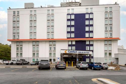 een groot wit gebouw met auto's geparkeerd op een parkeerplaats bij Comfort Inn & Suites Alexandria West in Alexandria