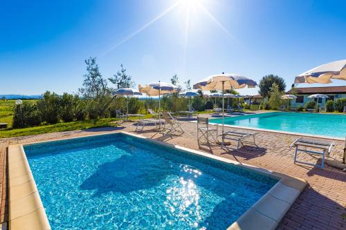 una piscina con ombrelloni e sedie e una piscina di Agriturismo Gli Etruschi a Populonia