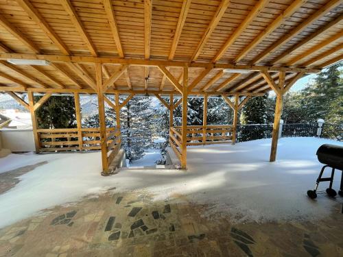 Pabellón grande con techo de madera y silla en BSG Villa - Sinaia, en Sinaia