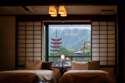 2 Betten in einem Zimmer mit Blick auf ein Fenster in der Unterkunft Kinsuikan in Miyajima