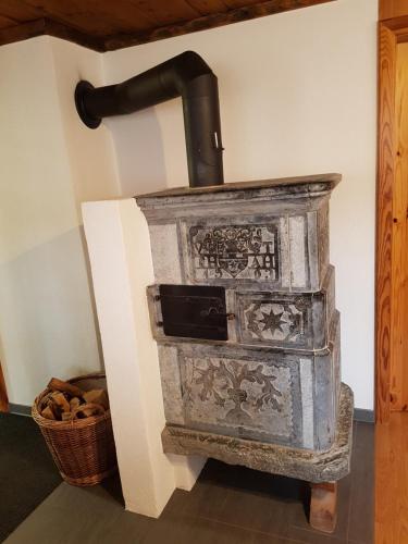 an old stone stove in a room with a basket at Imseng in Wiler