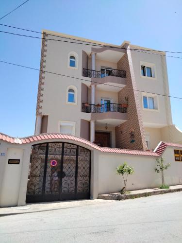 un grande edificio bianco con garage di Studio à Hammam Sousse a Hammam Sousse