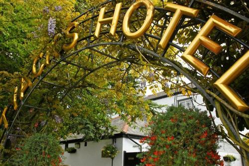 um sinal para uma casa com um monte de letras de ouro em Tyacks Hotel em Camborne