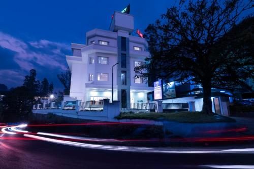 un edificio blanco con una bandera por la noche en Issacs Residency, en Munnar