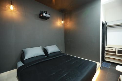 a bedroom with a large black bed with a window at Hotel Cineplex in Coimbatore