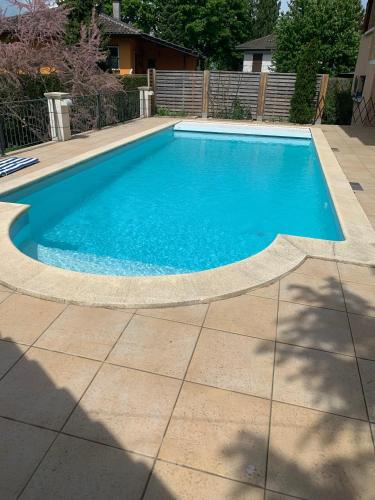 una piscina con acqua blu in un cortile di Chez les Michel a Viry