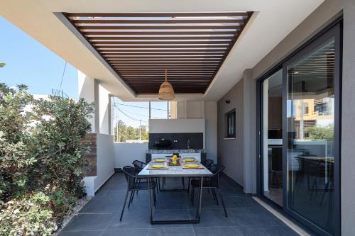 une salle à manger avec une table et des chaises sur une terrasse dans l'établissement VillAgioi Luxury Living, à La Canée