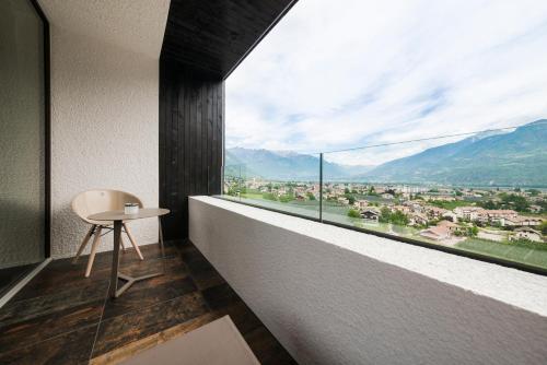 Zimmer mit einem Tisch und einem großen Fenster in der Unterkunft Garni Hotel Katzenthalerhof in Lana