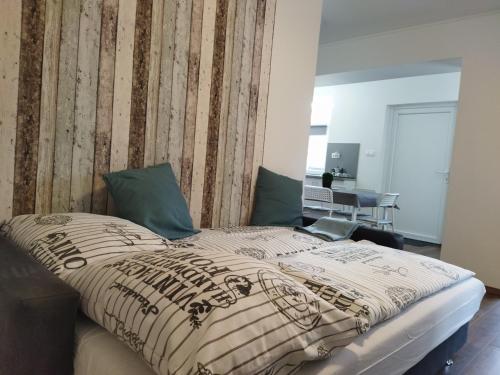 a bedroom with a bed with a wooden wall at Holdudvar Apartman in Gyula