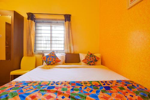 1 dormitorio con 1 cama en una habitación amarilla en FabHotel Vijaylakshmi Stay Inn - Nr Meenambakkam Metro Station, en Chennai