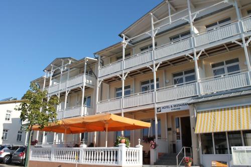 un grande edificio con un ombrello davanti di Hotel Selliner Hof a Ostseebad Sellin