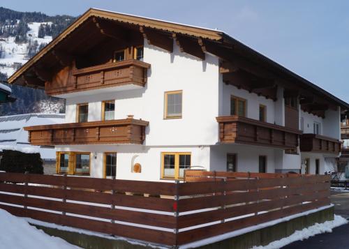 budynek z drewnianymi balkonami i ogrodzeniem w obiekcie Appartement Kröll Katharina w mieście Zell am Ziller