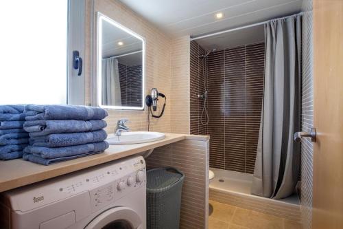 a bathroom with a washing machine and a sink at NIDO 150 Mestral in Roses