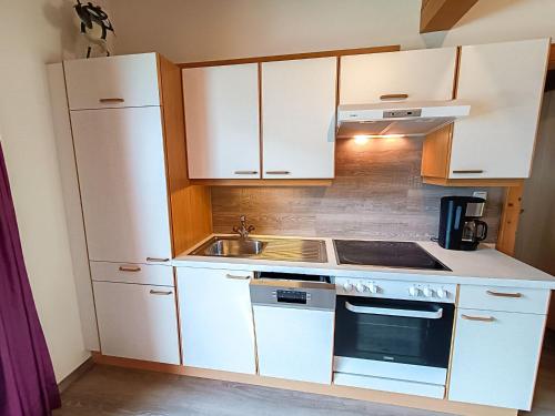 Elle comprend une petite cuisine avec des placards blancs et un évier. dans l'établissement Apartment Erna by Interhome, à Kappl