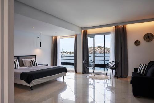 1 dormitorio con cama y vistas al agua en Xenia Poros Image Hotel, en Poros