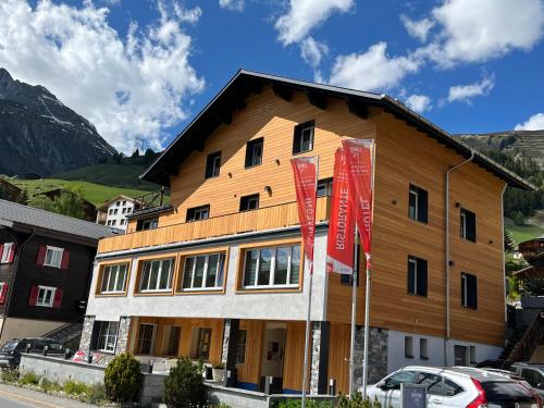 een groot gebouw met een houten dak bij Mountain Lodge Sedrun in Sedrun