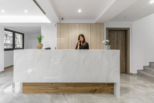 a woman talking on a cell phone in a lobby at Anassa Suites in Leptokaria