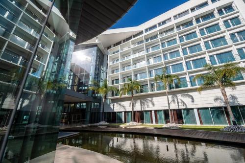 un edificio de oficinas con un estanque delante de él en Lagoas Park Hotel, en Oeiras