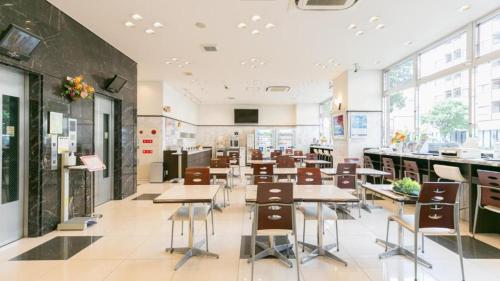 a cafeteria with tables and chairs in a building at Toyoko Inn Morioka eki Minami guchi Ekimae in Morioka