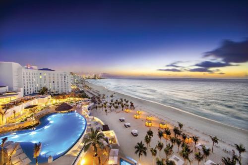 a view of the beach and the ocean at sunset at Le Blanc Spa Resort Cancun - Adults Only - All-Inclusive in Cancún