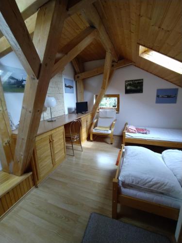 a bedroom with a bed and a desk in a attic at Apartmán v Srní in Srní