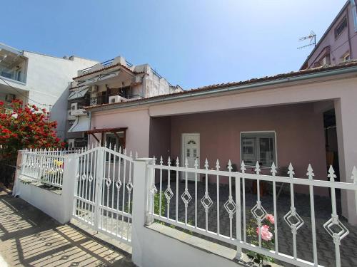 una cerca blanca frente a una casa en Lotaki the friendly house, en Limenaria