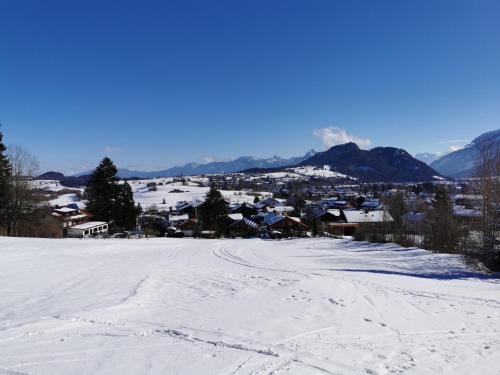 eine schneebedeckte Straße mit einer Stadt im Hintergrund in der Unterkunft Sunrise Belvedere Pfronten in Pfronten