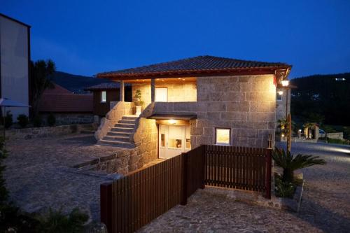 una casa de ladrillo con una valla delante de ella en Aldeia da Quinta do Paço, en Santo Tirso