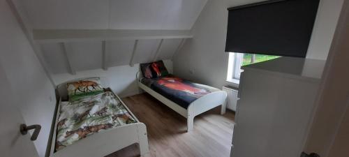 Habitación pequeña con cama pequeña y ventana en Vakantiehuis Mastdreef, en Breda