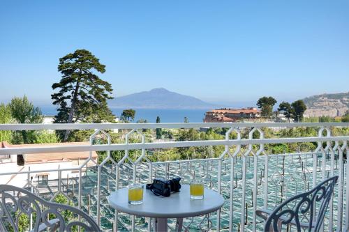 uma mesa numa varanda com vista para a água em Grand Hotel de la Ville em Sorrento