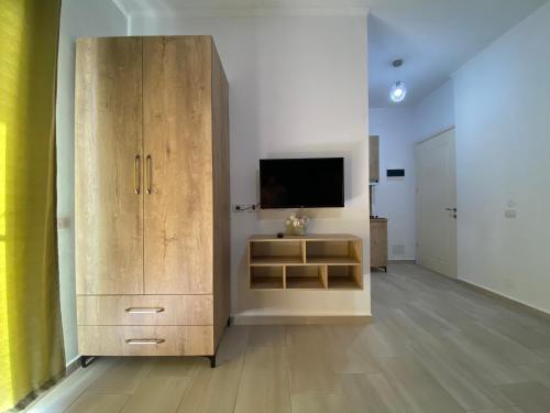 Cette chambre comprend une grande armoire en bois et une télévision. dans l'établissement Villa Luan Ksamil, à Ksamil