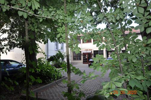 a view of a building through some trees at Parkhotel Schwedt in Schwedt