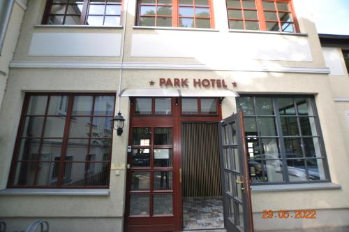 a park hotel building with a red door at Parkhotel Schwedt in Schwedt