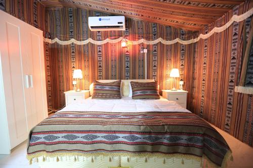 a bedroom with a large bed with two night stands at بيرحاء إبراء للسياحة in Ibrā