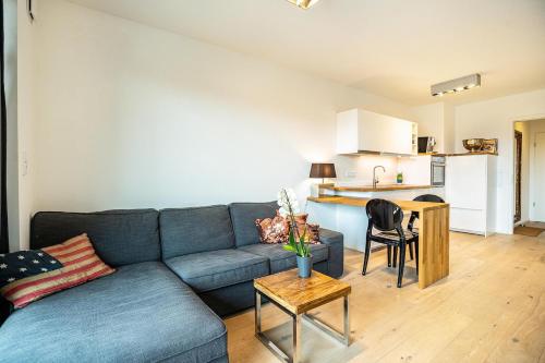 a living room with a blue couch and a kitchen at Weserloft 16 in Bremen