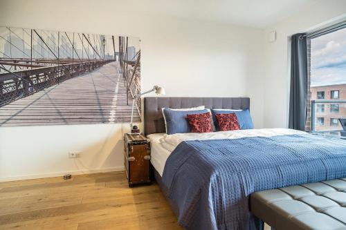 a bedroom with a bed with a bridge painting on the wall at Weserloft 16 in Bremen