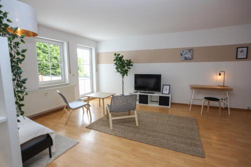 een woonkamer met een tv en een tafel en stoelen bij FullHouse - Eisenach - K70 Apartments - Elevator - Balcony - SmartTV in Eisenach